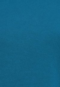 Tejido de algodón turquesa con una textura suave. Presenta un color uniforme sin patrones ni acentos, adecuado para prendas de vestir o tapicería.