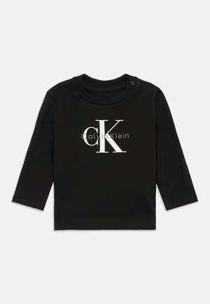 Crna dugosleeve majica za bebe s Calvin Klein "cK" logom u bijeloj i sivoj boji na prednjem dijelu, s okruglim izrezom i dugmetom za rame.