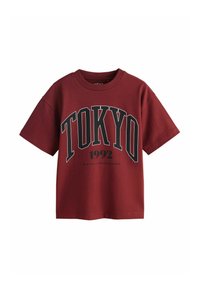 Dunkelrotes Kurzarm-T-Shirt mit dem Schriftzug "TOKYO" in großen schwarzen und weißen Buchstaben sowie "1992" darunter in schwarzer Schrift.