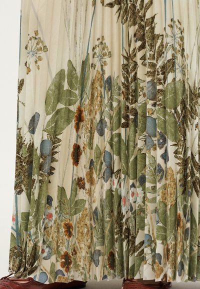 Φούστα από πλισέ ύφασμα με λουλουδένιο σχέδιο που περιλαμβάνει πράσινα φύλλα, μπλε μούρα και πορτοκαλί λουλούδια σε ανοιχτό μπεζ φόντο.