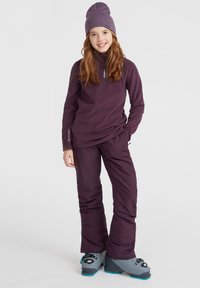 Paarse fleece top met lange mouwen en ritsnek, gecombineerd met bijpassende paarse skibroek en grijze skischolen, met zwarte accenten en details.