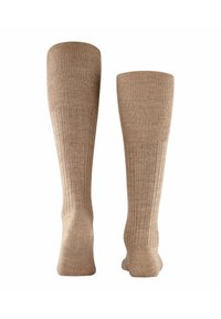 Calze beige alte fino al ginocchio con un design a costine, realizzate in un tessuto morbido. Presentano una trama liscia e una punta rinforzata per una maggiore durata.