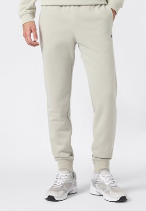 Pantalones de chándal gris claro con cintura elástica, puños acanalados y bolsillos laterales, que presentan un pequeño logo bordado en el muslo.