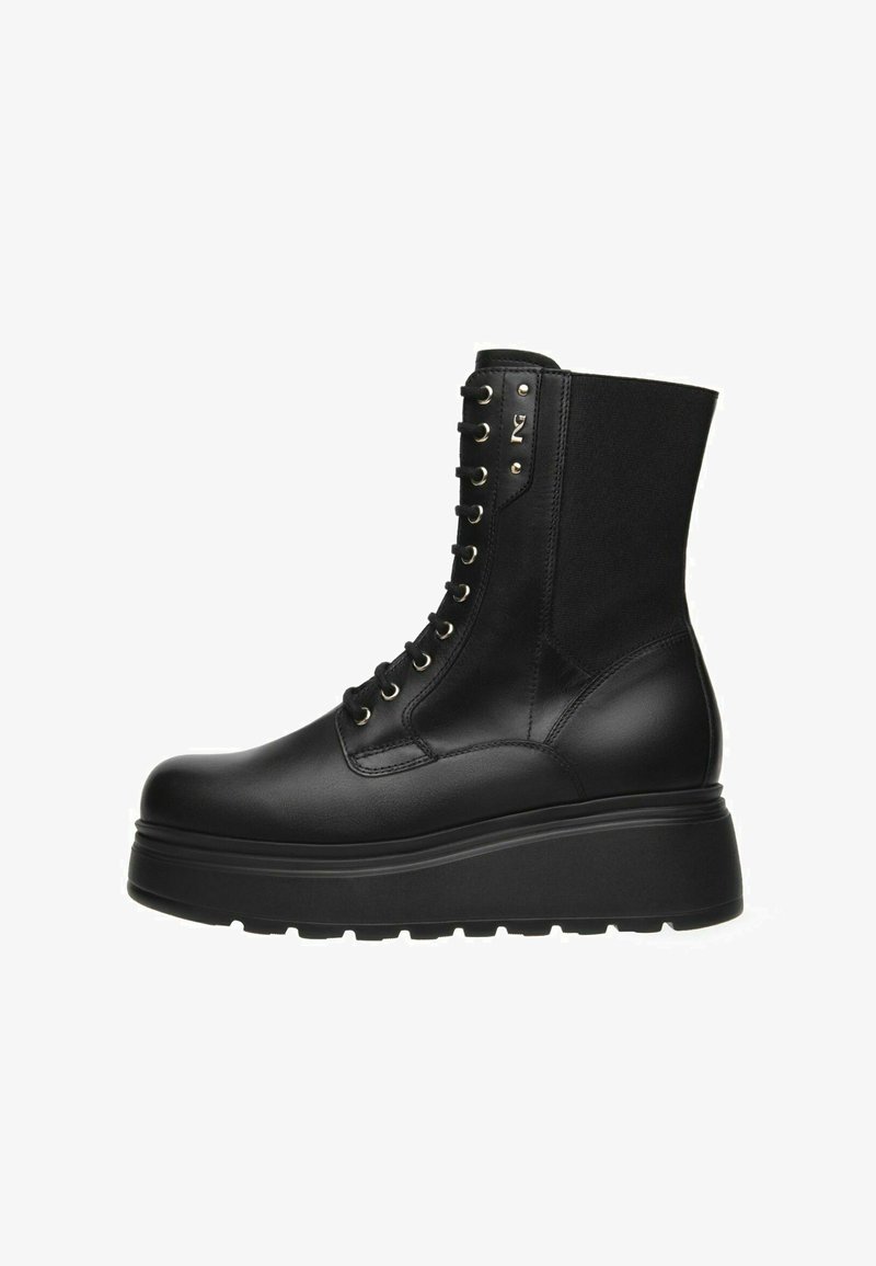 Botte de combat en cuir noir à plateforme avec un devant à lacets, une semelle épaisse et un panneau élastique sur le dos supérieur.
