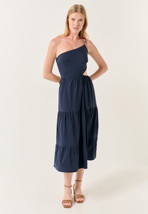 Abito navy a spalla unica con design a strati, realizzato in tessuto morbido. Presenta un taglio laterale e una tracolla regolabile per una vestibilità ottimale.