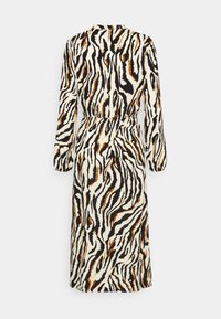 Robe midi à manches longues avec taille élastique, présentant un motif zèbre noir, blanc et marron sur un tissu léger.