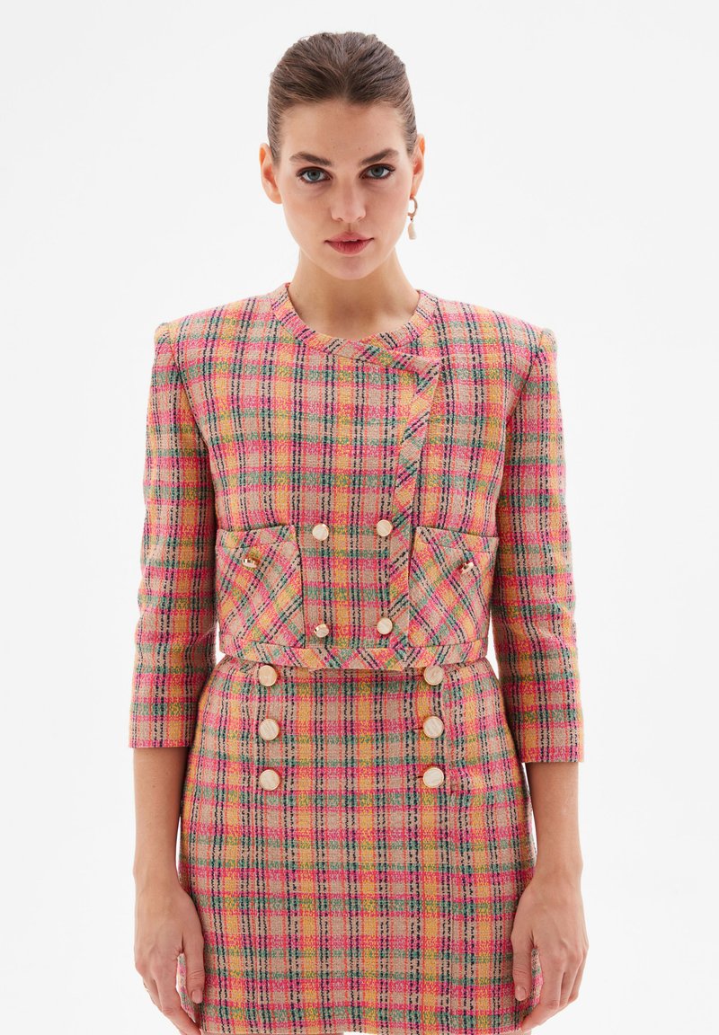 Pink and yellow checkered tweed jacket with three-quarter sleeves, a fitted silhouette, pockets, and large button details.