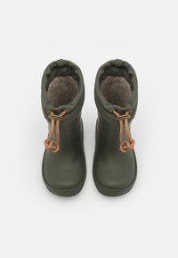 Bottes en caoutchouc vertes avec une doublure douce grise, dotées d'une fermeture à cordon et d'accents en cuir en haut. Design à bout rond.
