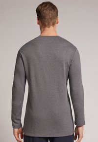 Grijze lange mouwen shirt met een ronde hals, zachte textuur en een rechte zoom, met minimale stiksels en geen zichtbare logo's of patronen.
