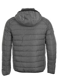 Giacca puffer grigia con cappuccio, caratterizzata da un design trapuntato, motivi cuciti e polsini elastici. Il materiale sembra testurizzato e isolante.