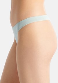 Ljusblå tanga i mjukt tyg med en slät textur och en minimalistisk design. Har en bred midjeband och inga synliga sömmar för diskret bärande.
