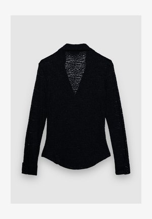 Schwarzes langärmeliges Hemd mit strukturiertem Stoff, V-Ausschnitt-Design und mit Knöpfen versehene Manschetten. Verfügt über ein dezentes gewebtes Muster im gesamten Stoff.