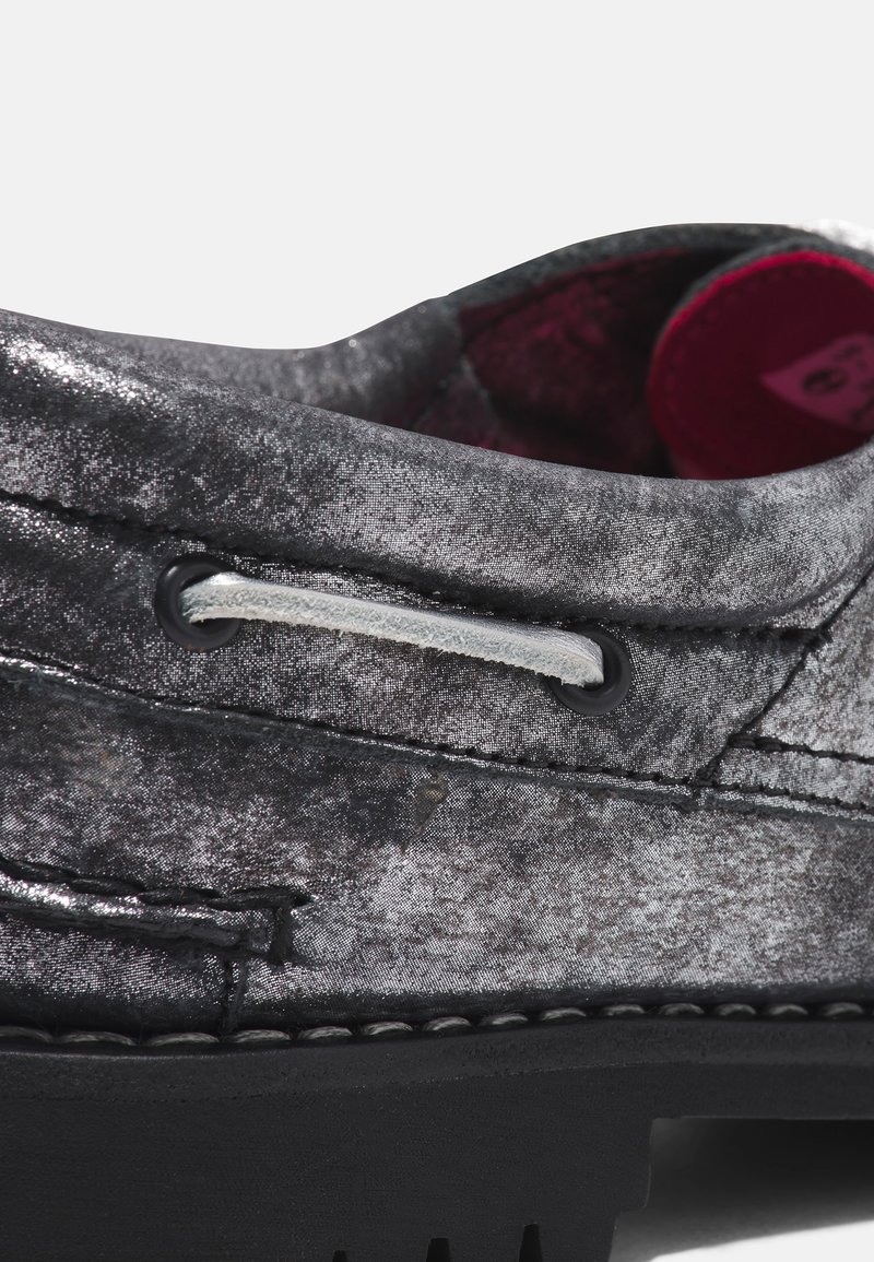 Scarpa in tessuto grigio con finitura metallizzata, lacci bianchi a contrasto e suola in gomma nera con cuciture visibili e dettagli dei fori.