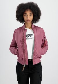 Veste bomber rose avec fermeture éclair à l'avant, poignets et taille côtelés. Elle dispose d'une poche latérale avec fermeture éclair et d'un logo sur la poitrine.
