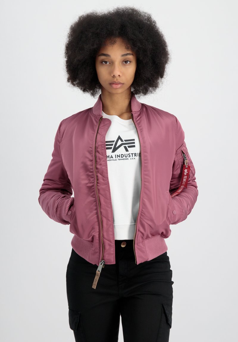 Veste bomber rose avec fermeture éclair à l'avant, poignets et taille côtelés. Elle dispose d'une poche latérale avec fermeture éclair et d'un logo sur la poitrine.