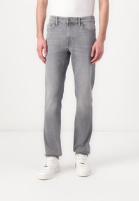 Pilkas džinsų audinio kelnes su tiesia siluetu, vidutinio aukščio liemeniu, klasikine penkių kišenių konstrukcija, subtiliu išblukimu ir mygtukų uždarymu.