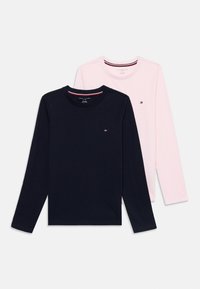 Two long-sleeve t-shirts: one navy blue with small logo, one light pink, both made of soft cotton, featuring a crew neck and stitched hem.