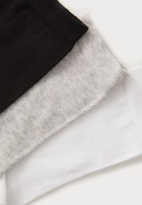 Drei Stoffbänder in Schwarz, Grau und Weiß, mit gerippten Texturen und sauberen Kanten, horizontal auf einem hellen Hintergrund gestapelt.