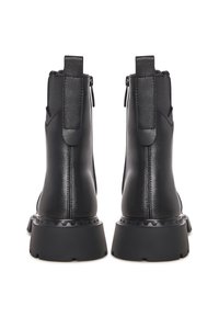 Botas de tobillo negras con un material sintético liso, paneles laterales elásticos y una suela texturizada. Cuenta con una pestaña en la parte posterior y un tacón grueso.