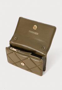 Portafoglio in pelle trapuntata verde oliva con chiusura a scatto dorata e logo. Presenta un comparto con zip e tasche per carte interne.