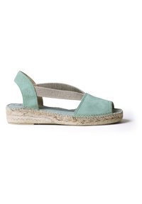 Minttu vihreä mokkanahkainen espadrille avonaisella varpaalla ja joustavalla hihnalla. Luonnollinen juuttipohja, jossa on palmikko-ompeleet. Rento, kevyt muotoilu.