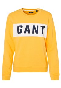 Geel sweatshirt van katoen, met een witte horizontale streep met zwarte "GANT" letters over de borst. Ribgebreide manchetten en zoom.
