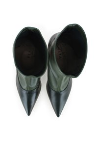 Bottines vertes et noires avec un design à bout pointu, dotées d'un extérieur en cuir lisse et d'un tige en caoutchouc texturé.