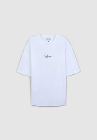 T-shirt bianca oversize realizzata in cotone, con maniche corte e scollatura rotonda. Scritta ricamata "Los Angeles" in azzurro chiaro sul davanti.