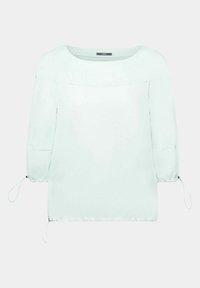 Blouse bleu clair à manches longues avec encolure bateau et cordons réglables aux manches et à l'ourlet sur un fond uni.