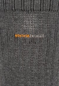 Dark gray knit fabric with vertical ribbing and a textured finish, featuring an orange stitching detail in the center.