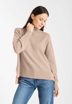 Beige hoge-neklong met geribbelde manchetten en zoom, gemaakt van een zacht stof. Het ontwerp heeft een relaxte pasvorm en zijsplitten.