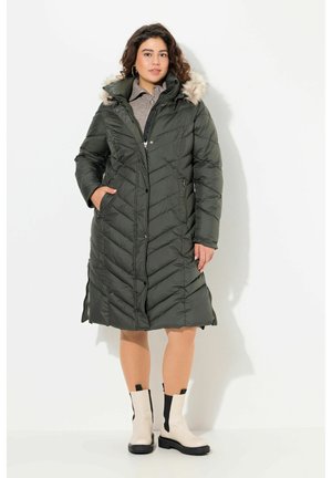 Olive green, knee-length puffer coat with chevron stitching, fur-lined hood, and side pockets; worn with beige ankle boots.