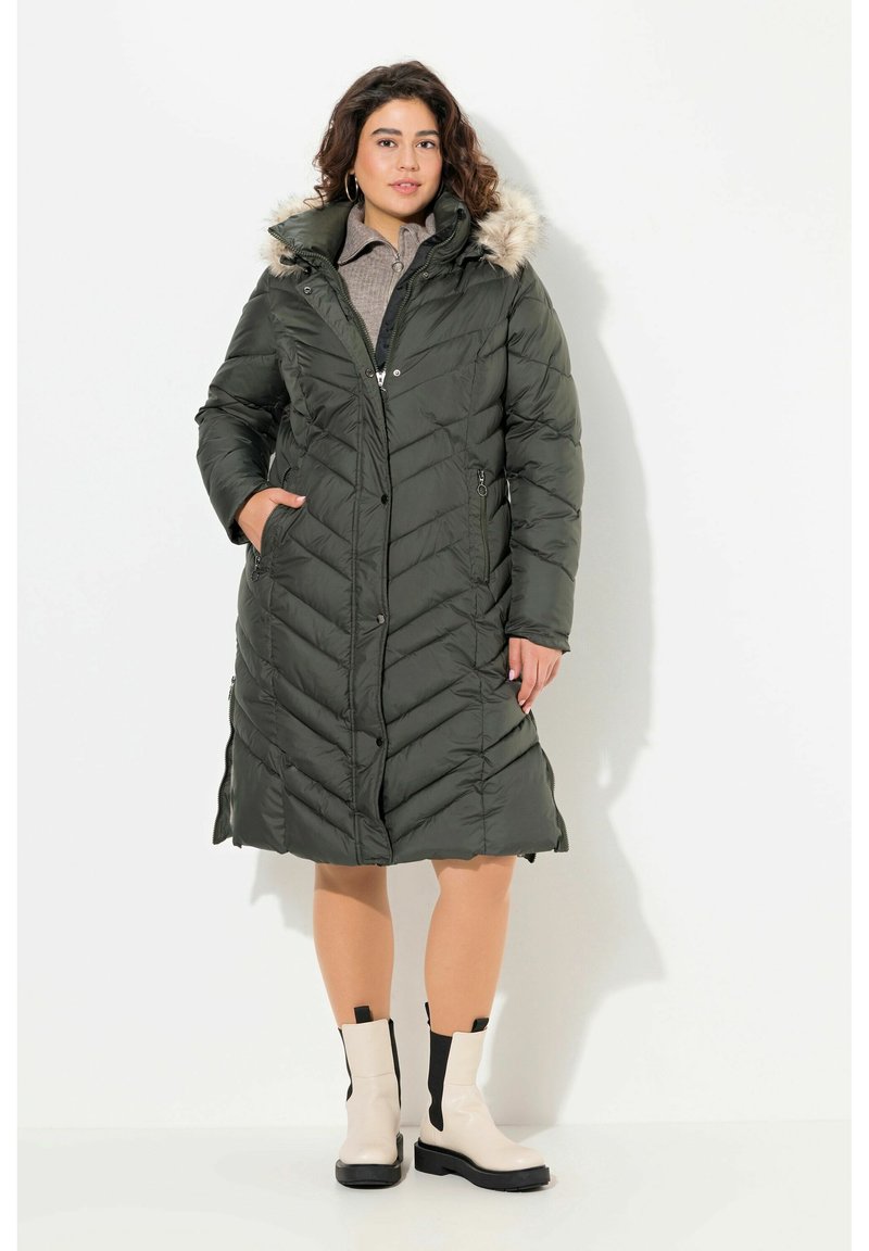 Olivgrön, knälång pufferjacka med Chevron-söm, foder i päls och sidofickor; använd med beige ankelboots.