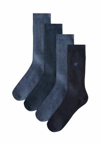 Vier Paare dunkelblauer Socken in verschiedenen Farbtönen, mit gerippten und glatten Texturen, wobei ein Paar ein kleines gesticktes Logo aufweist.