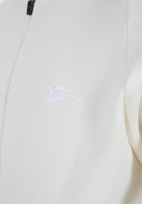 Gevoerd sweatshirt in crèmekleurige katoen met een textuurafwerking. Kenmerkt een subtiele witte geborduurde logo op de linkerkant van de borst.