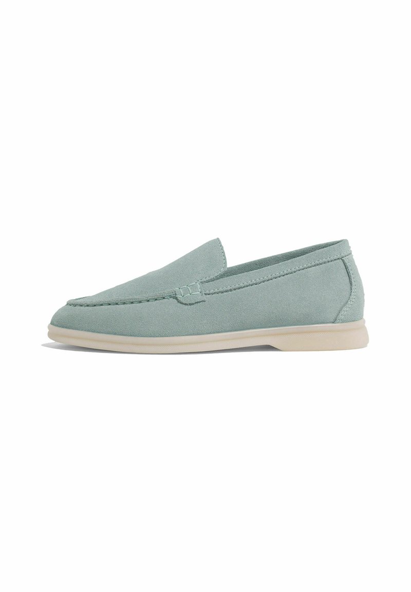 Mocassini in suede verde chiaro con suola bassa in gomma, caratterizzati da un accento cucito sulla parte anteriore e una finitura liscia.