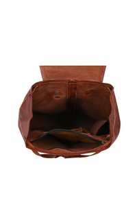 Otevřený hnědý kožený batoh, ukazující prázdnou hlavní přihrádku a vnitřní zipovou kapsu s zvednutým víkem.