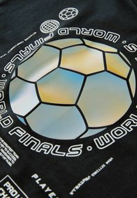 T-shirt noir arborant un grand graphique de ballon de football stylisé aux couleurs irisées, entouré de texte en accents blancs et argentés.