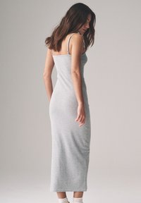 Szara midi sukienka z dzianiny elastycznej, z cienkimi ramiączkami, dopasowanym krojem i rozcięciem po boku, prezentująca gładką fakturę tkaniny i prosty design.