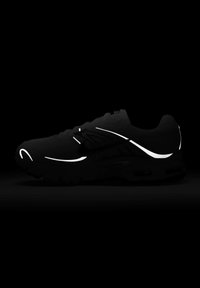 Černá sportovní bota s reflexními akcenty, má texturovaný svršek, polstrovanou podrážku a elegantní design. Pozadí je tmavé.