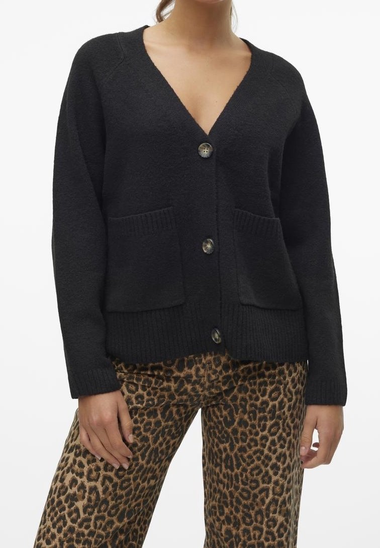 Cardigan noir à col en V, cinq boutons et deux poches avant. Doté de poignets et d'un ourlet côtelés. Porté par-dessus un pantalon imprimé léopard.