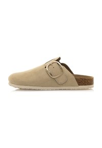 Zapato beige de ante sin cordones con puntera redondeada, detalle de hebilla lateral, plantilla de corcho y suela de goma blanca texturizada.