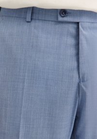 Hellblaue maßgeschneiderte Hose aus strukturiertem Stoff, mit einem Knopfverschluss und einem scharfen Bügel in der Vorderseite.