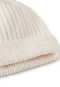 Biała, prążkowana czapka beanie z miękkiego materiału, z grubym zawiniętym mankietem oraz subtelną wytłoczoną etykietą z wzorem królika.