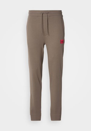 Bruine sweatpants van een katoenmix, met een rood logo-embleem, een elastische tailleband met trekkoord en een taperende pijpdesign.