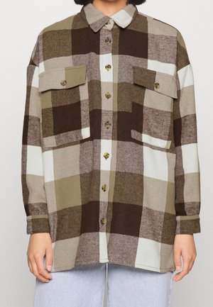 Camicia in flanella a scacchi marrone e crema con due tasche frontali, chiusura con bottoni e colletto a punta. Tessuto morbido e vestibilità comoda.