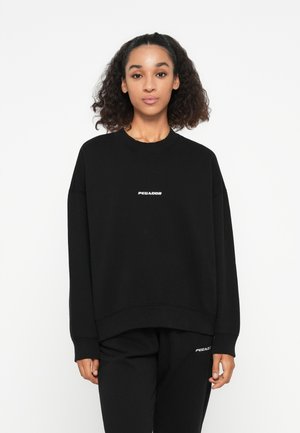 Black sweatshirt with a crew neckline, featuring a white logo "PEGADOR" on the chest. Made of a soft fabric, with a relaxed fit.