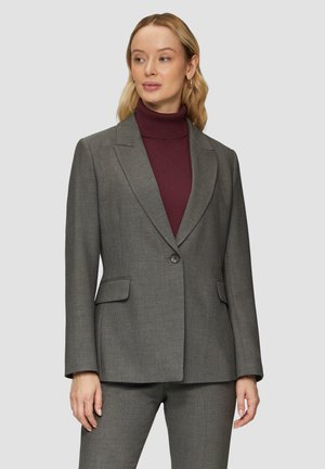 Grijze blazer met notch lapels, een enkele knoopsluiting en twee voorkeurszakken. Zachte, gestructureerde stof, gecombineerd met een bordeauxrode coltrui eronder.