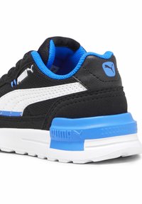 Czarne trampki z niebieskimi akcentami, białym paskiem, teksturowaną siateczką i wyściełanym kołnierzem. Posiada wyraźne logo Puma na pięcie i boku.