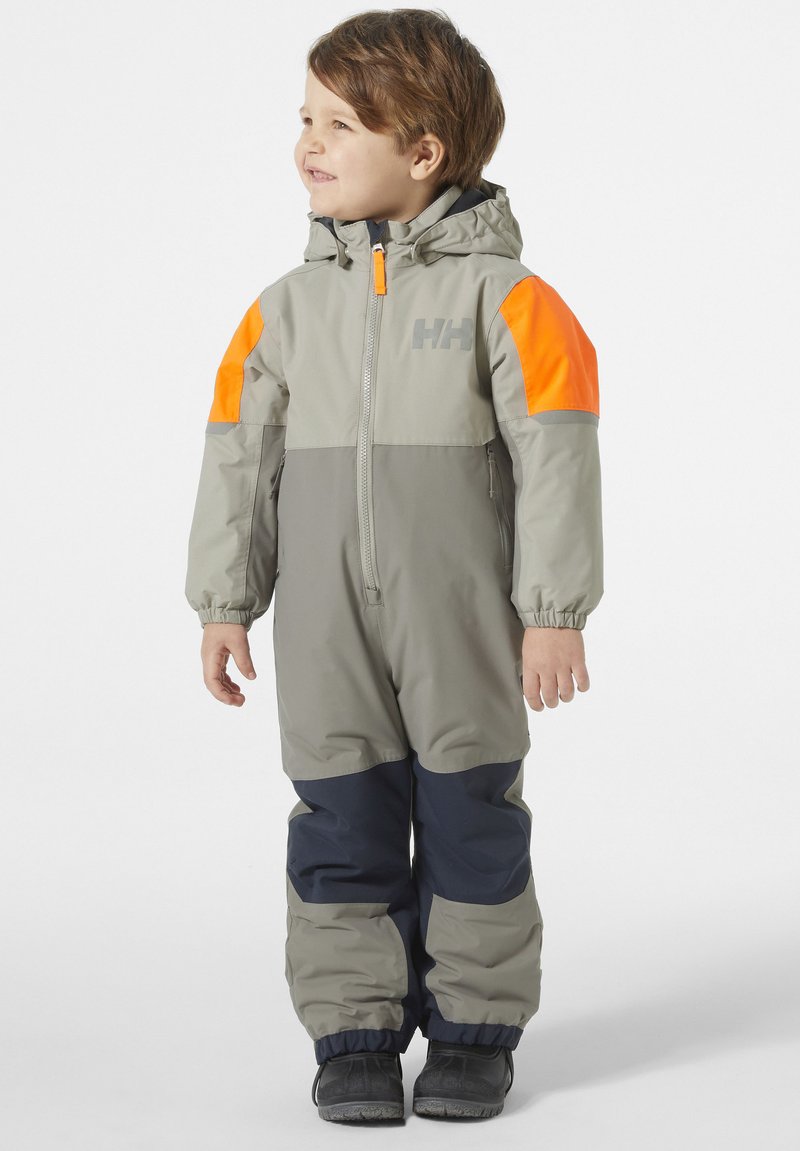 Kinderwaterdichte overall, grijs met oranje accenten. Bevat een capuchon, lange mouwen, elastische manchetten en duurzame stof voor buitengebruik.